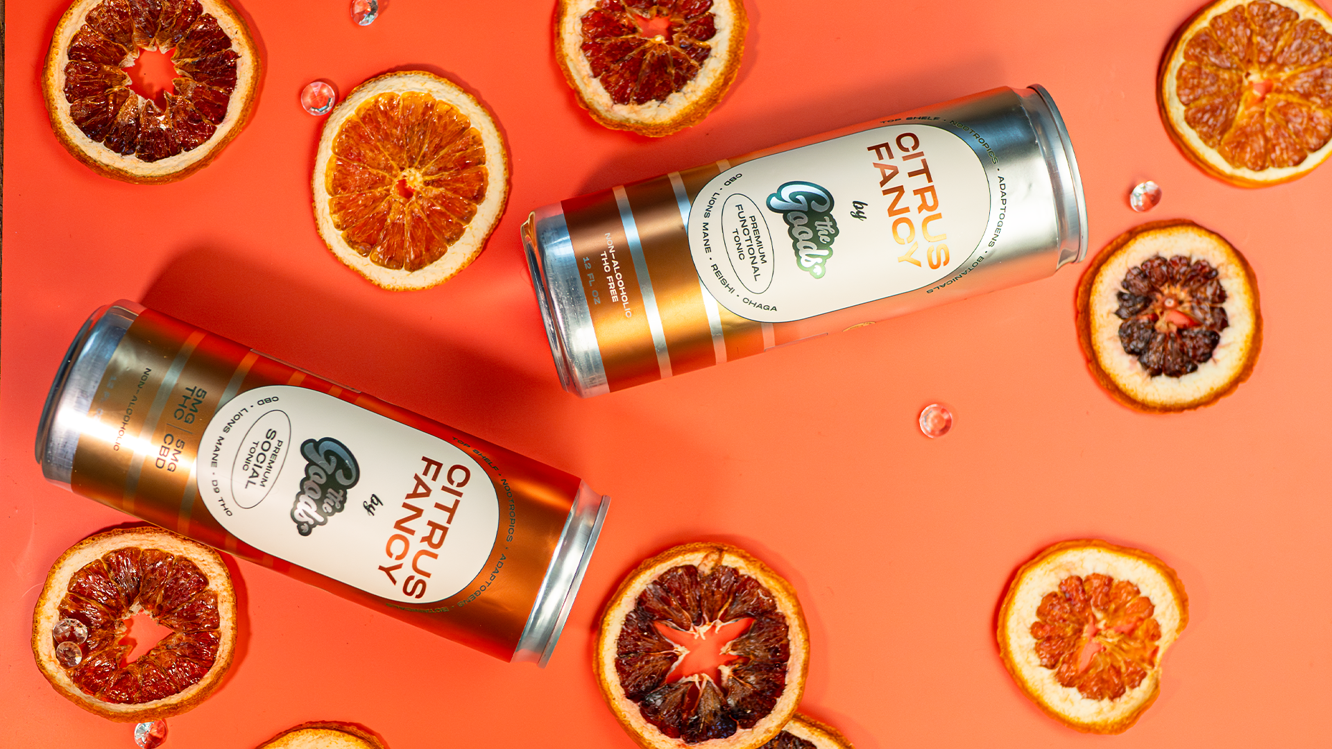Citrus fancy social tonic and functional tonic in front of an orange background next to orange slices scattered about