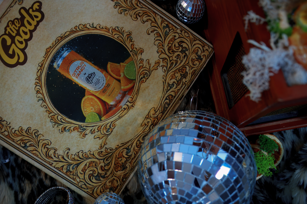 a disco ball and record cover showing 'The Goods' logo