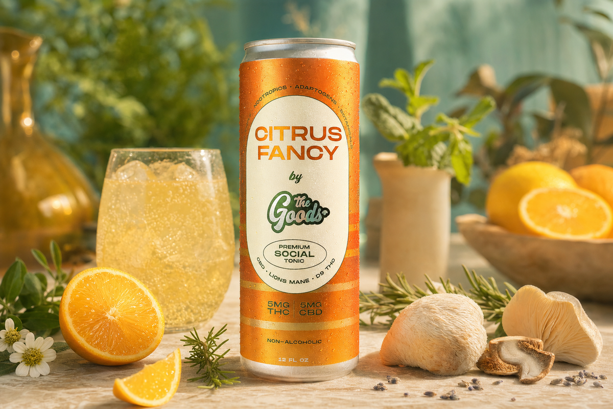 Citrus Fancy THC/CBD social tonic can beside a filled glass, orange halves, mushrooms, and herbs.