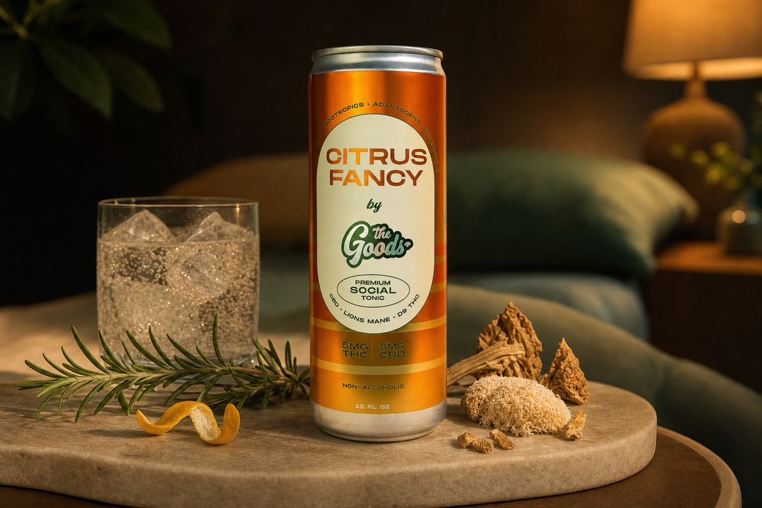 Orange "Citrus Fancy" THC-CBD social tonic can on a stone table with iced glass, rosemary, and mushrooms.