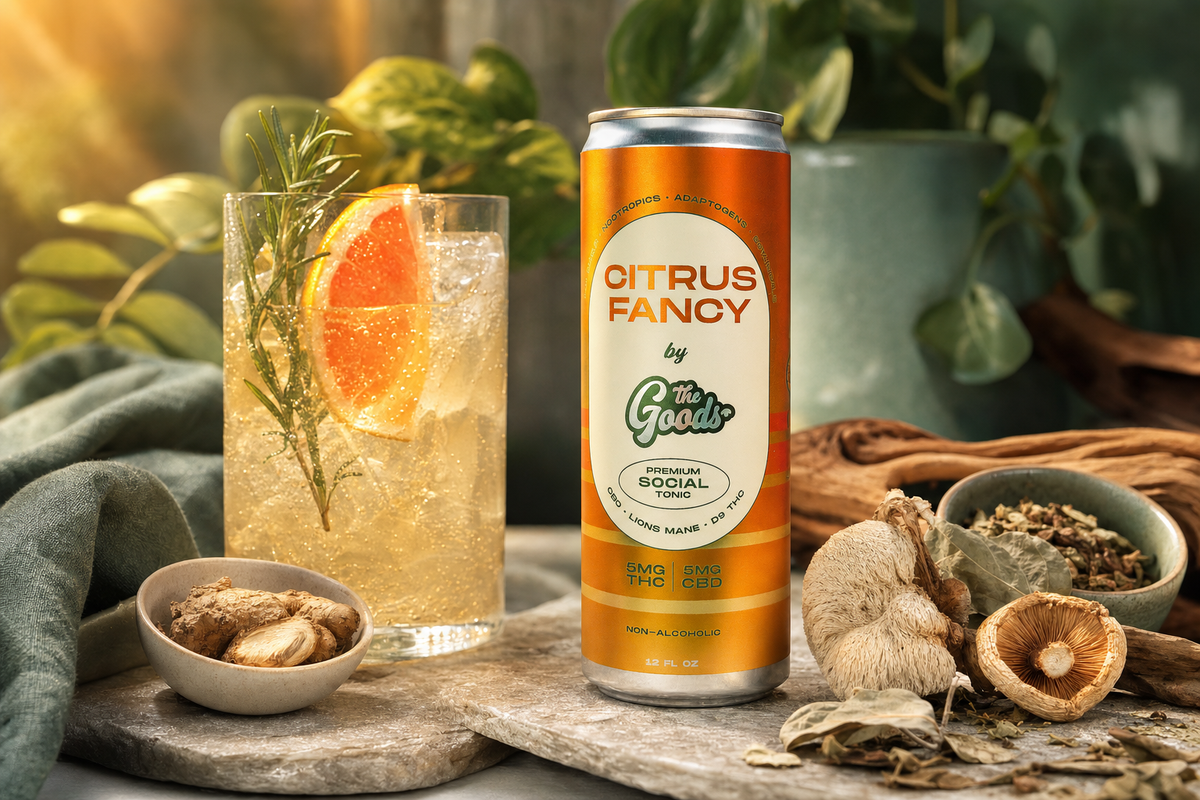 Citrus Fancy social tonic can beside a grapefruit cocktail, ginger, and mushrooms among greenery.