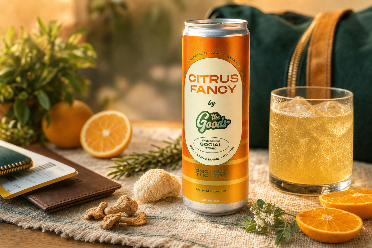 Citrus Fancy THC social tonic can beside an iced drink, oranges, mushrooms, and a wallet with a boarding pass.