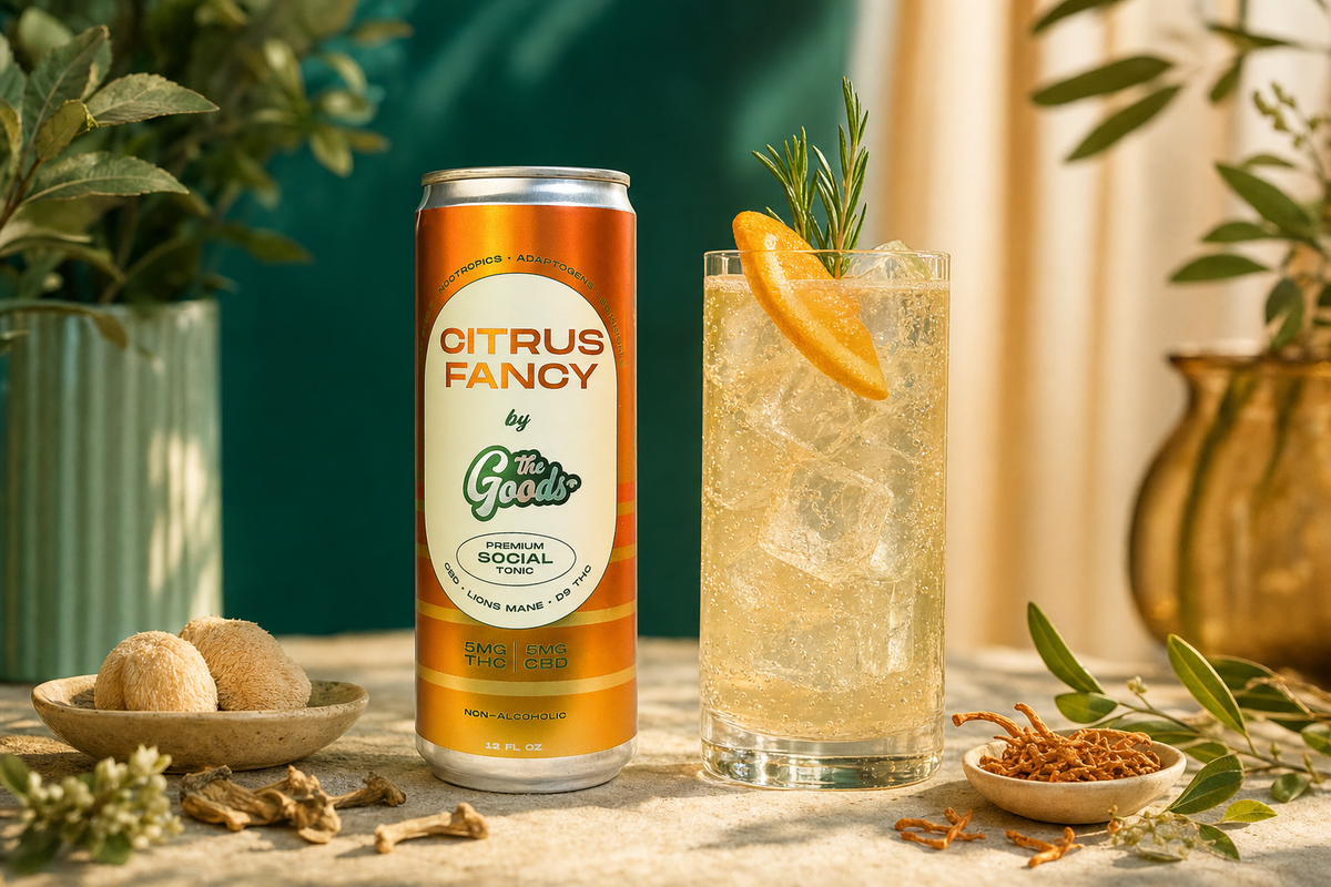 Citrus Fancy THC social tonic can beside a fizzy iced drink garnished with orange and rosemary, with mushrooms and greenery.