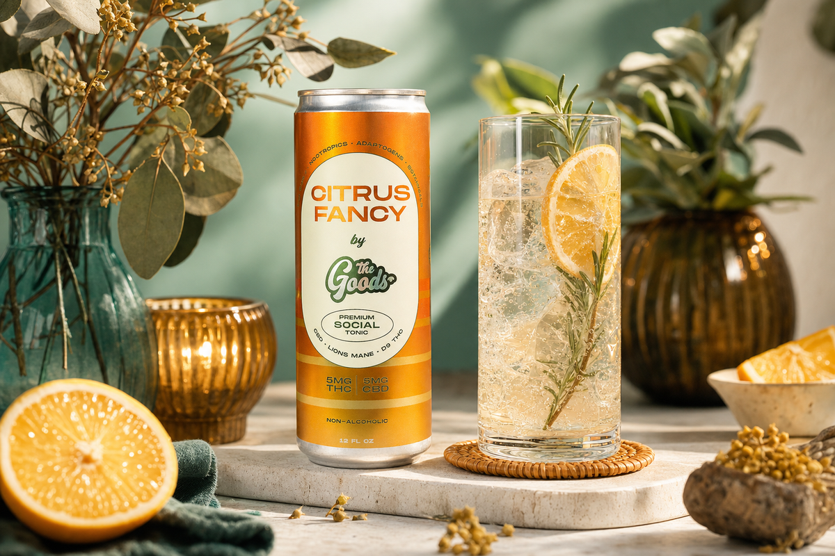 Citrus Fancy THC social tonic can beside a tall glass cocktail with orange slice and rosemary, styled with greenery and oranges.