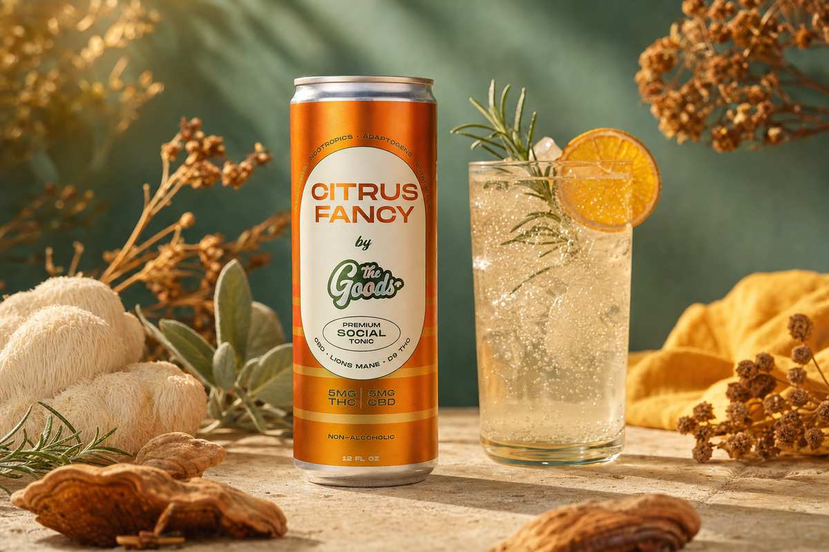 Orange "Citrus Fancy by The Goods" THC social tonic can beside a fizzy drink with orange slice and rosemary, among mushrooms.