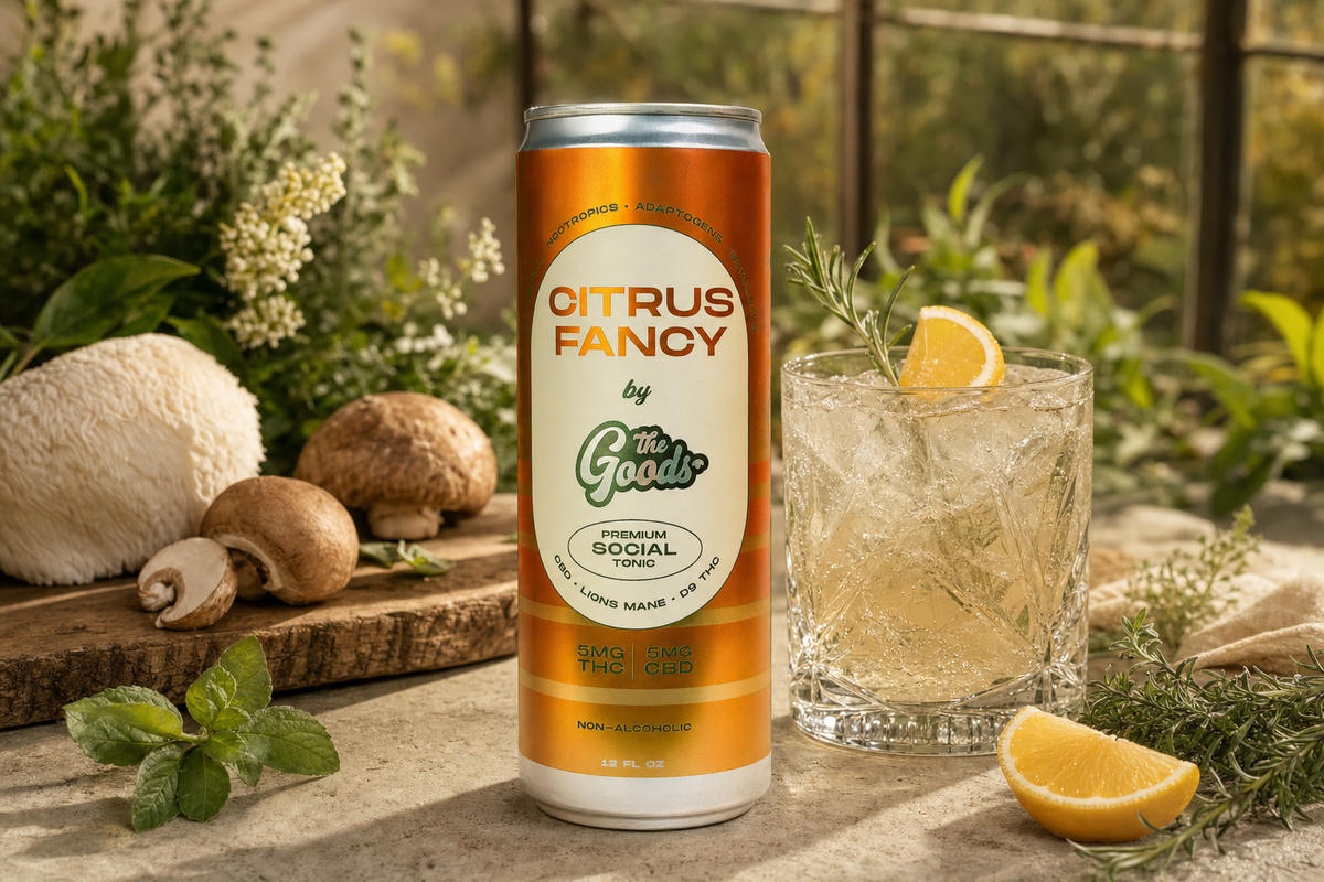 Citrus Fancy THC and CBD social tonic can beside an iced cocktail with lemon and rosemary, mushrooms and herbs nearby.