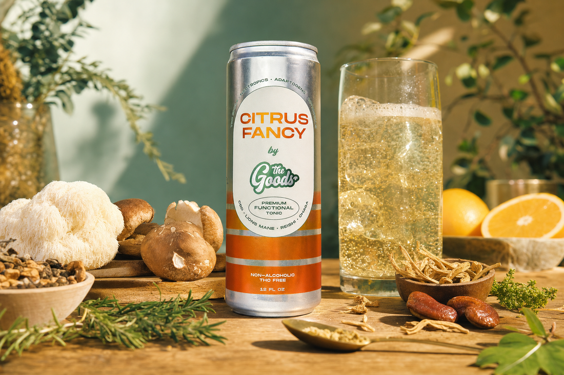 Citrus Fancy functional tonic can beside a glass of sparkling drink, surrounded by mushrooms, herbs, and citrus.
