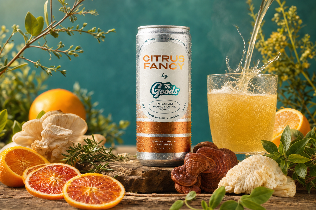 Citrus Fancy functional tonic can beside a splashing glass, blood oranges, and mushrooms on wood against teal.