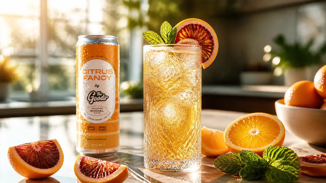 a can of The Goods Citrus Fancy Social Blend next to a glass of orange liquid on a counter